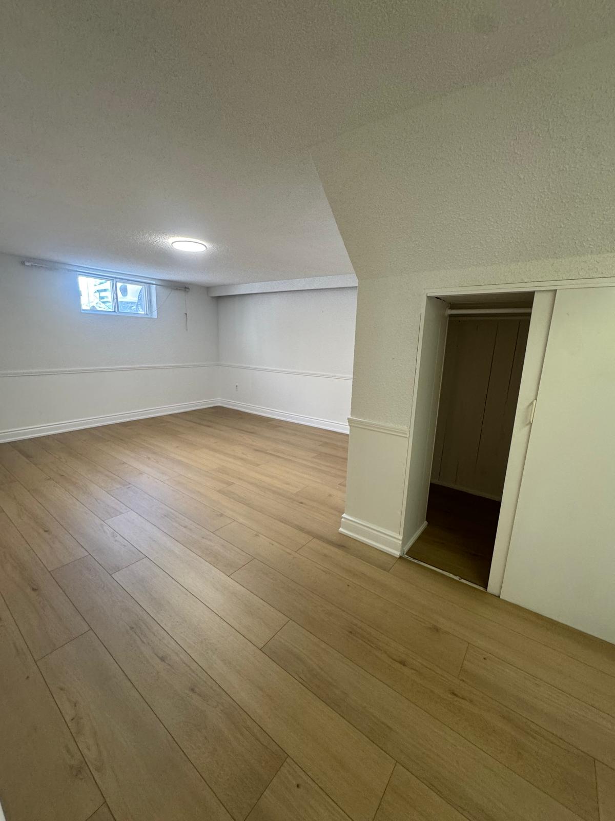 Basement bedroom with natural oak luxury vinyl plank flooring